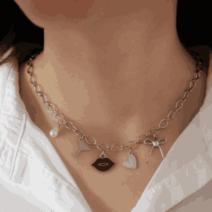 Collier argenté à maillons porté autour du cou, orné de cinq charms pendentifs : une perle, un verre de cocktail, des lèvres, un cœur et un nœud, style délicat et romantique