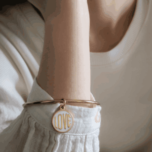 Jonc LOVE Blanc doré porté sur un poignet féminin