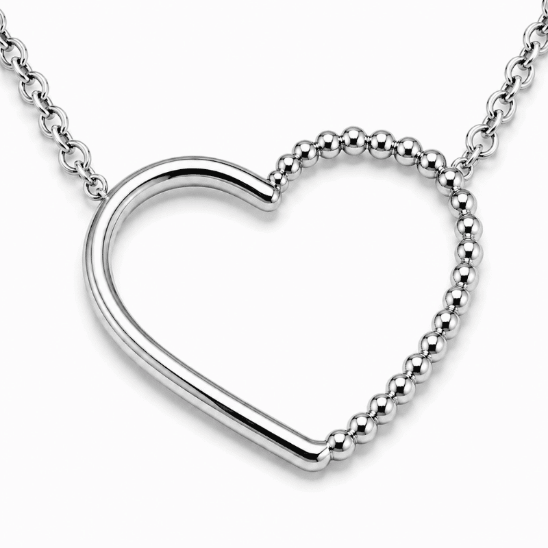 Les Paulinas, zoom sur la chaîne et le pendentif du collier Paulina Précieuse argenté Zoom sur la chaîne fine et le pendentif cœur du collier Paulina Précieuse argenté en acier inoxydable Les Paulinas