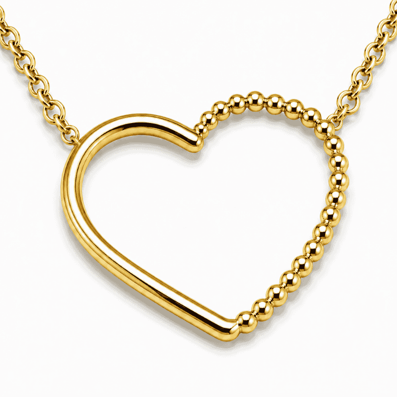 Les Paulinas, zoom sur la chaîne et le pendentif du collier Paulina Précieuse doré Zoom sur la chaîne fine et le pendentif cœur du collier Paulina Précieuse doré en acier inoxydable Les Paulinas