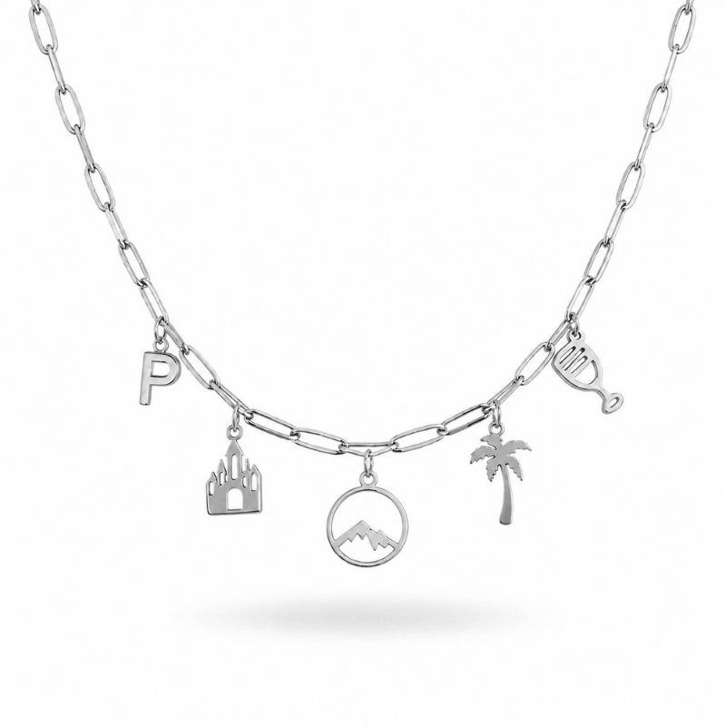 Les Paulinas, collier béarnais argenté à charms en acier inoxydable Collier béarnais argenté à charms en acier inoxydable avec lettre P, château, Pic du Midi d’Ossau, palmier et verre de vin, sur chaîne Paulina Originale Les Paulinas