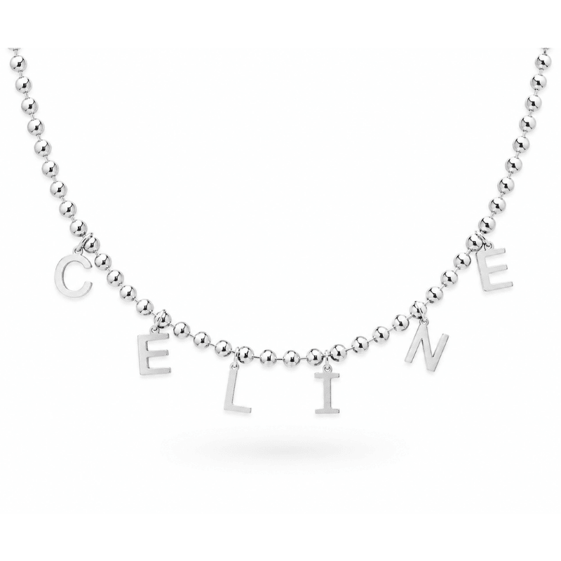 Les Paulinas, collier personnalisable Céline Dion argenté Collier personnalisable argenté inspiré de Céline Dion avec les lettres C E L I N E sur une chaîne Paulina Audacieuse Les Paulina