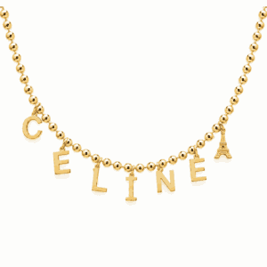 Collier personnalisable doré inspiré de Céline Dion avec les lettres C E L I N E et un charm Tour Eiffel, souvenir de son retour sur scène et de sa tournée